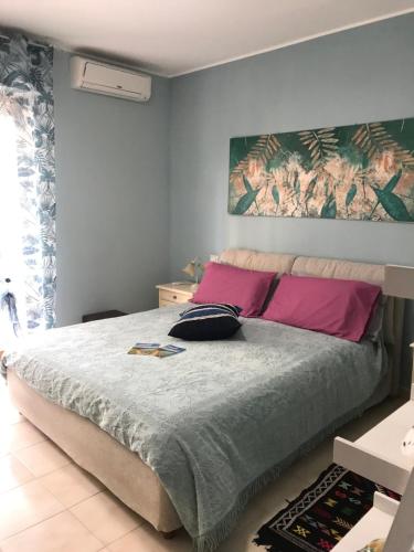 - une chambre avec un grand lit et des oreillers roses dans l'établissement Casa Vacanze La Carezza, à Montesilvano