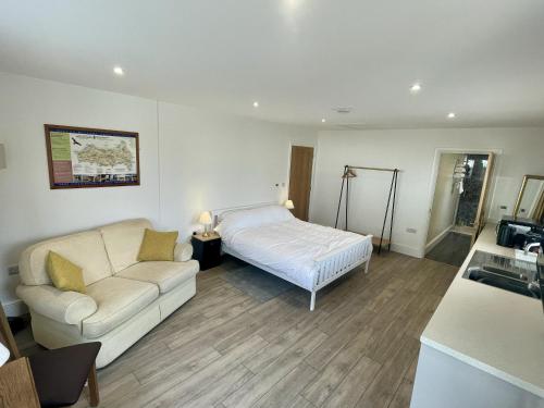 a living room with a bed and a couch at Large New Studio Apartment and Hot Tub - Private Hideaway in the Brecon Beacons in Bwlch