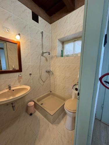 y baño con lavabo, aseo y ducha. en Karaván guest house, en Hollókő