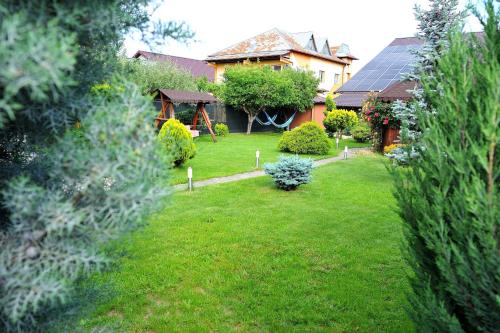 een tuin met een huis met een zonnedak bij Casa Cri și Ramo in Bradu