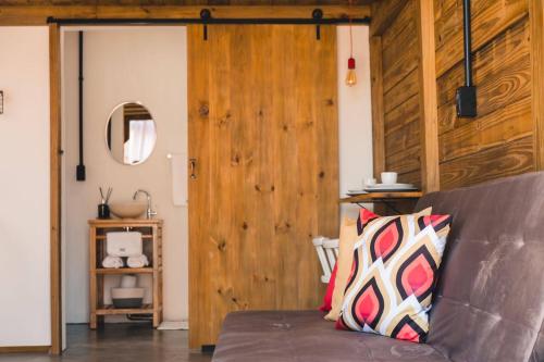 uma sala de estar com um sofá e uma parede de madeira em Fire Whip House em Penha