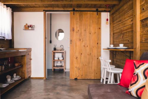 um quarto com uma porta de madeira e uma mesa e cadeiras em Fire Whip House em Penha