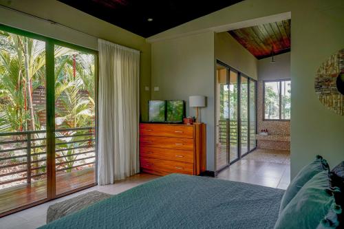 a bedroom with a bed and a dresser with a television at Casa Vista Verde in Uvita