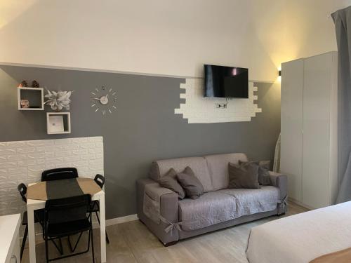 a living room with a couch and a tv on the wall at Magda House & Parking in Bari