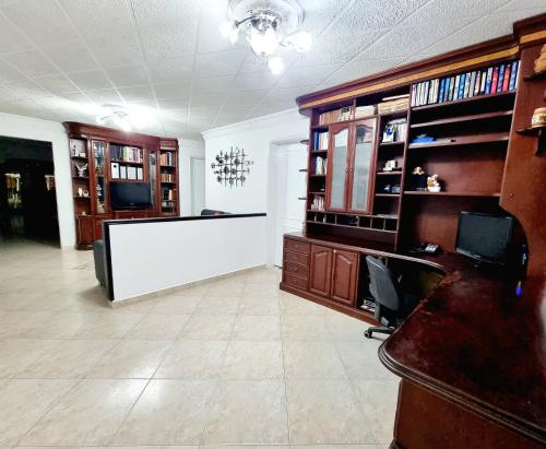 a large office with a reception desk and bookshelves at Hermosa casa en Bucaramanga in Bucaramanga