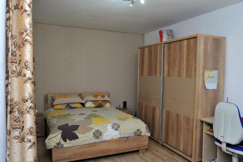 a bedroom with a bed and a wooden cabinet at Casa Cri și Ramo in Bradu