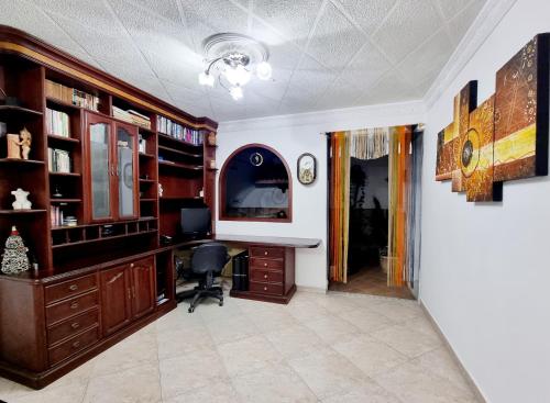 a home office with a desk and book shelves at Hermosa casa en Bucaramanga in Bucaramanga