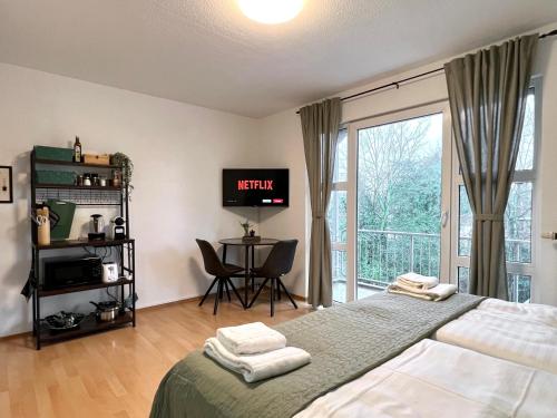 1 dormitorio con cama, escritorio y ventana en Sali - E1 - WLAN, Balkon, TV, en Essen