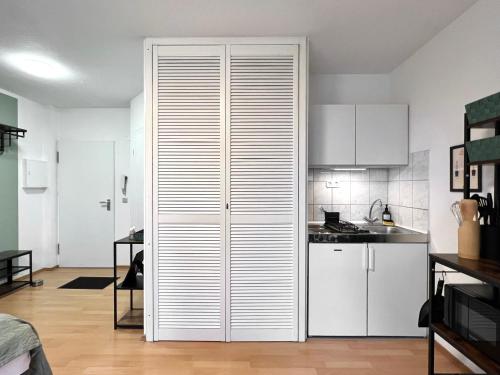 uma cozinha com armários brancos e um grande armário em Sali - E1 - WLAN, Balkon, TV em Essen