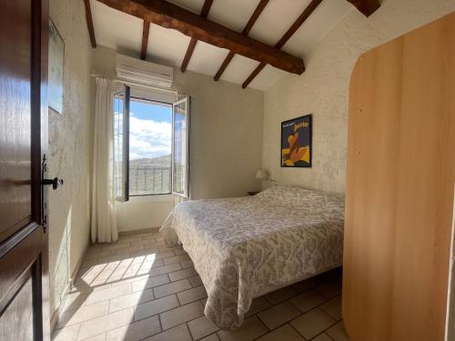 une chambre avec un lit et une grande fenêtre dans l'établissement La maison Collines de Guerrevieille, à Sainte-Maxime
