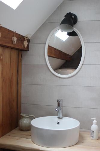 uma casa de banho com um lavatório branco e um espelho. em Beau duplex vue sur le Lac Blanc em Orbey