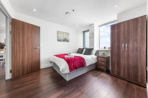 a bedroom with a bed and a large window at New Apartment 20 mins from London Waterloo BP65 in London