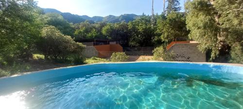 a swimming pool with blue water in a yard at Hospedaje Serrano Suyuque Viejo in San Luis