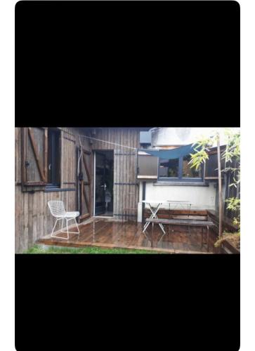 une terrasse avec un banc, une table et une chaise dans l'établissement Maison avec terrasse-jardin proche métro, à Montreuil