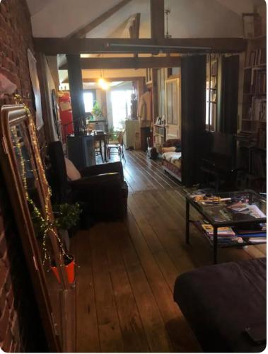 - un salon doté de meubles et d'un mur en briques dans l'établissement Maison avec terrasse-jardin proche métro, à Montreuil