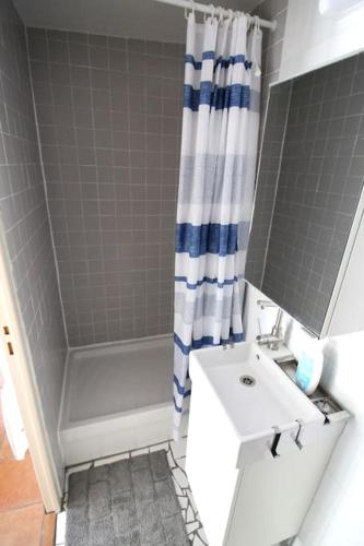 une salle de bain avec un lavabo blanc et une douche dans l'établissement Studio au calme proche Libération, à Nice