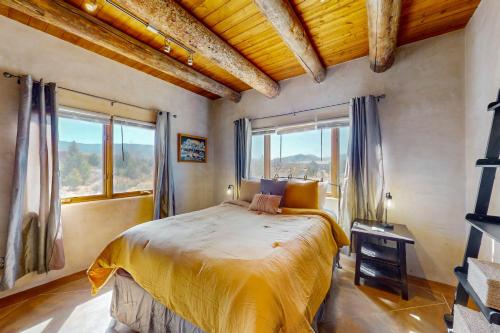 a bedroom with a large bed in a room with windows at Pow Days Taos in Taos