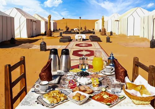 a table with food on it in the desert at Sahara Berber Camp in Zagora