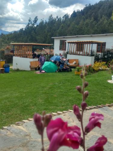 a group of people in a yard with a house at El Rincón de Gabo in Nobsa