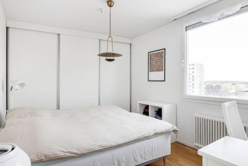 - une chambre blanche avec un lit et une fenêtre dans l'établissement Quiet City Style Apartment, à Täby