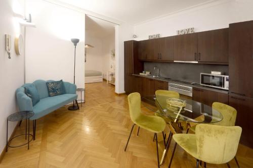 a living room with a glass table and yellow chairs at Residenza al Colosseo in Rome