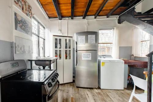 uma cozinha com um fogão e um frigorífico em Habitaciones Smith Alquiler The Smith Guesthouse em San José