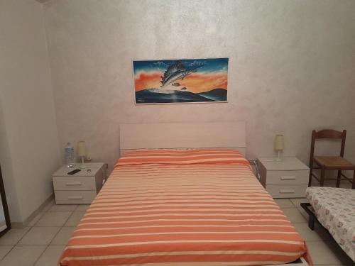 een slaapkamer met een bed en een schilderij aan de muur bij Villa Rosa in Santa Caterina