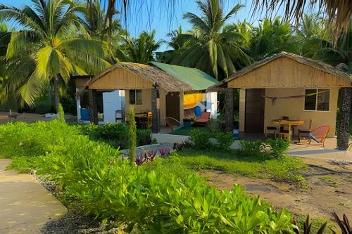 a house on the beach with palm trees at Casa Las Palmas Playa La Saladita in Zihuatanejo