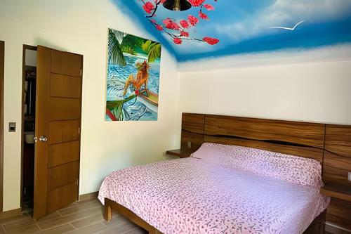 a bedroom with a bed and a painting on the ceiling at Casa Las Palmas Playa La Saladita in Zihuatanejo