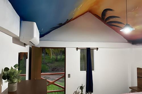 a room with a ceiling with a painting on it at Casa Las Palmas Playa La Saladita in Zihuatanejo