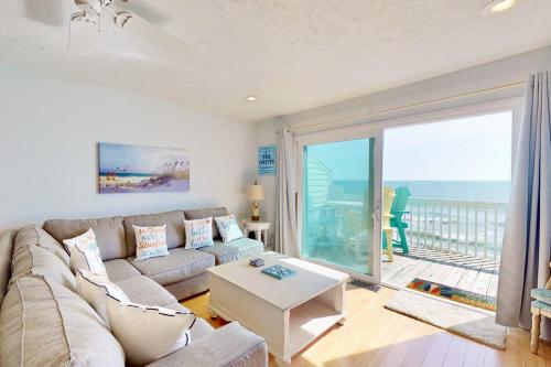 a living room with a couch and a view of the ocean at Sea Forever in Kure Beach