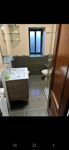 a bathroom with a sink and a toilet and a window at Precioso chalet cerca de la playa de Samil in Vigo