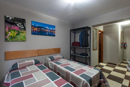 a bedroom with two beds and a checkered floor at Gente del Sur - Godoy in Ushuaia