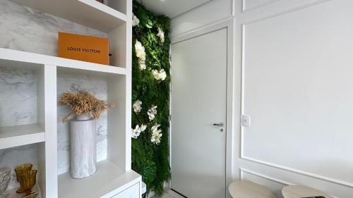 a bathroom with a walk in shower and a vase of flowers at 23- Studio Luxo Perfeito in Curitiba