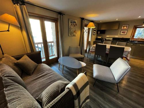 un salon avec un canapé et une table dans l'établissement Résidence L'escarel - Chalet mitoyen à 150m du téléski MAE-4051, à Saint-Martin-de-Belleville