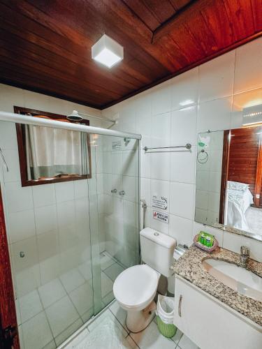 a bathroom with a toilet and a shower and a sink at Village dos Pássaros in Belo Oriente