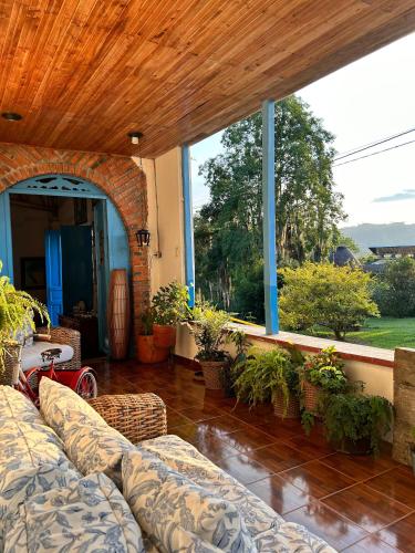 a living room with a couch and a large window at Buriti EcoH RNT56521, via Termales Santa Rosa de Cabal in Santa Rosa de Cabal