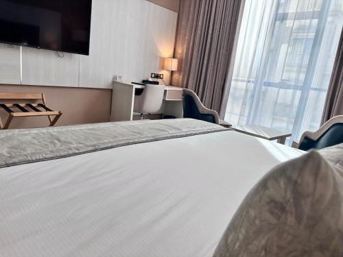 a hotel room with a bed and a large window at 2H Hotel in Oran