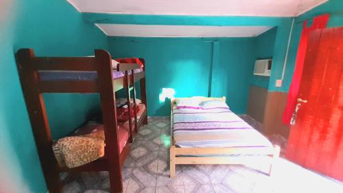 a room with two bunk beds and a blue wall at LOLI Guest House Iguazú Habitaciones privadas con baño in Puerto Iguazú