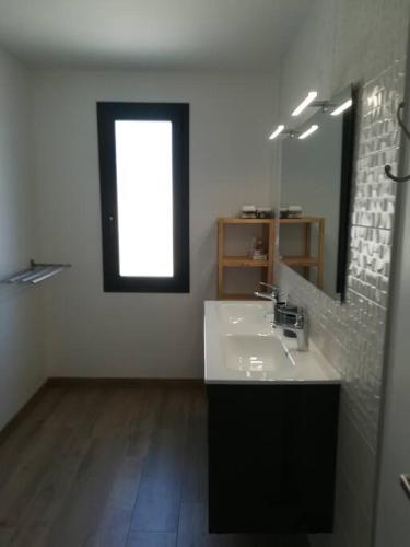 une salle de bain blanche avec un lavabo et un miroir dans l'établissement Location proche plage de Penvins, Sarzeau, à Sarzeau