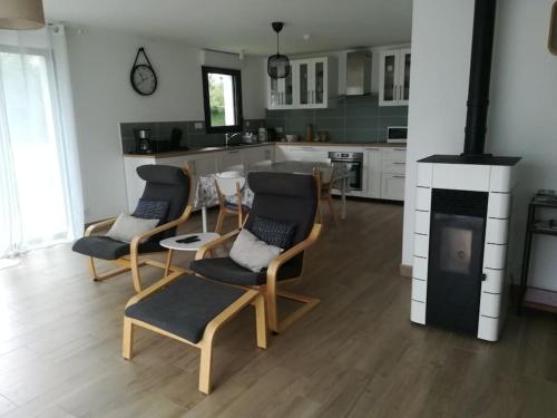 une cuisine avec quatre chaises, une table et une cuisinière dans l'établissement Location proche plage de Penvins, Sarzeau, à Sarzeau