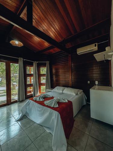 a bedroom with two beds in a room with wooden ceilings at Village dos Pássaros in Belo Oriente