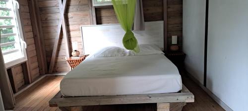 a bedroom with a white bed in a room at Le Bougainvillier Blanc in Pointe-Noire