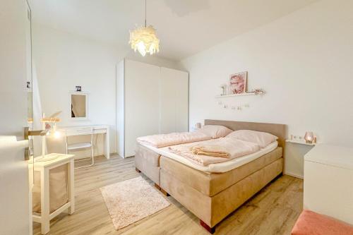a white bedroom with a bed and a desk at Modernes Trierer CityLoft mit großem Balkon in Trier