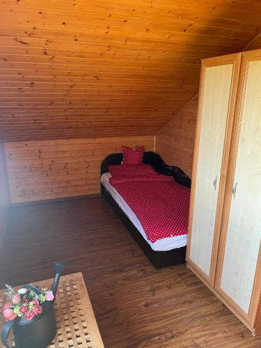 a small room with a bed in a wooden cabin at Nimród apartman in Gabčíkovo