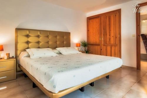 a bedroom with a large bed with a large headboard at Waterfront villa with breathtaking views and pool in Colera