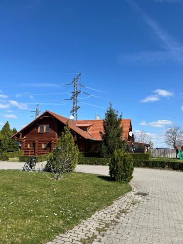 a wooden house with a brick walkway in front of it at Nimród apartman in Gabčíkovo