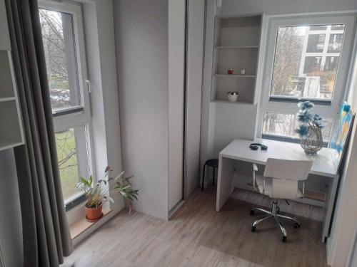 an office with a desk and two windows at Słońce Bemowa in Warsaw