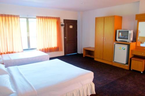 a hotel room with two beds and a television at Sichang Shine Khao Resort in Ko Si Chang