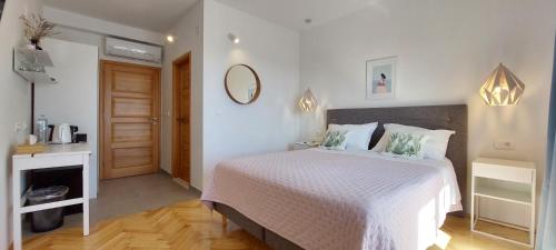 a bedroom with a white bed and a mirror at Vila Luka 2 in Hvar